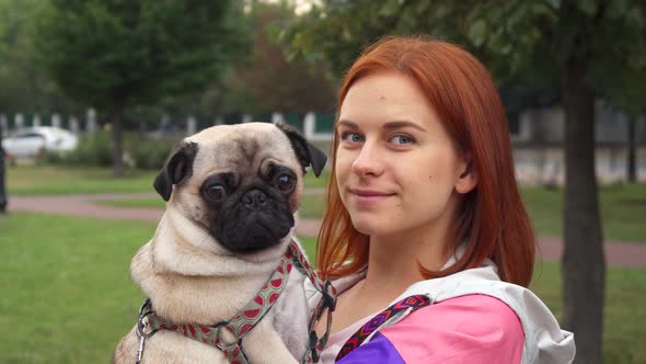 Girl Holding Her Pug and Smiling at Camera alt