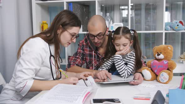 Father with His Little Daughter at the Reception at the Family Doctor in the Clinic alt
