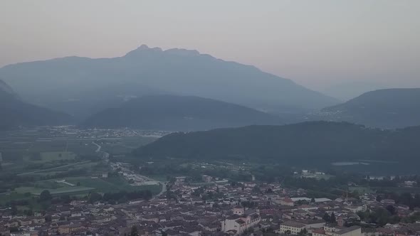 Aerial panoramic view of Levico Terme, Italy, during sunrise with drone panning left to right alt