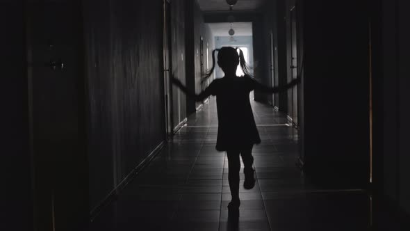 Silhouette of Little Girl Jumping the Rope in Corridor 