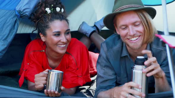 Couple sharing coffee in tent alt