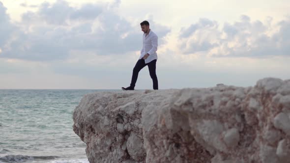 Young Happy Man Sit on the High Hill of Rock and Enjoying Amazing View of Seaside and Beautiful alt