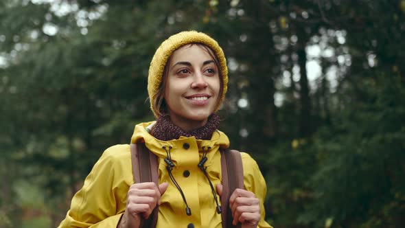 Slow Motion Portrait Young Woman in Red Jacket on Mountain Top at Sunset with Sun Raises and Flares alt