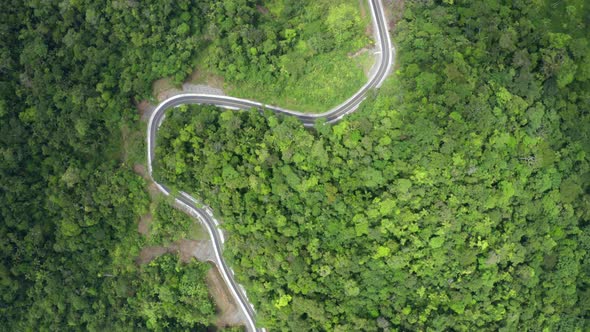 A closed curve in the road winding through the hills of the Andes in Ecuador alt