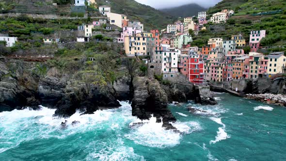 Cinque Terre Drone Video of Riomaggiore Italy rocky coast with crashing waves alt