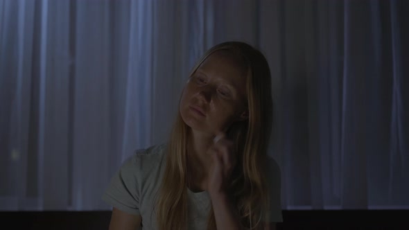 A Woman at Night Turns on a Meditation Relaxation Application to Relax Before Going to Bed alt