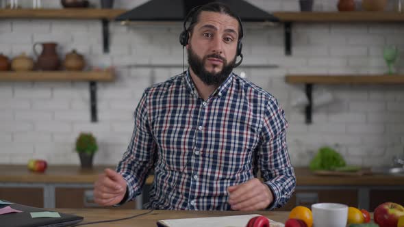 Video Chat POV of Confident Middle Eastern Positive Man in Earphones Talking Discussing Business alt