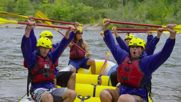 Group of people white water rafting celebrate