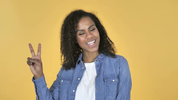 Victory Sign By African Girl Isolated on Yellow Background alt