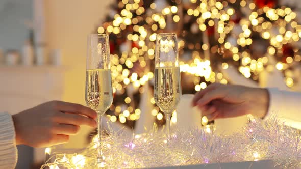 Hands of Man and Woman Are Taking Wine Glasses with Champagne in Xmas Eve.