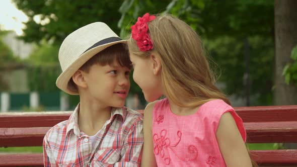 Little Girl Tells Something To the Boy on the Bench alt