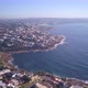 Aerial flight over coastal beachfront coastal property ocean houses with city view in the background