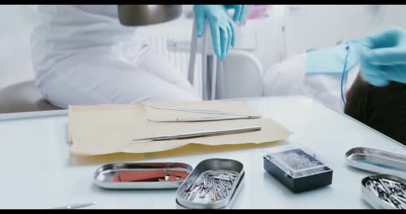 The Hands of a Dentist Take Devices for Examining the Patient's Oral Cavity alt
