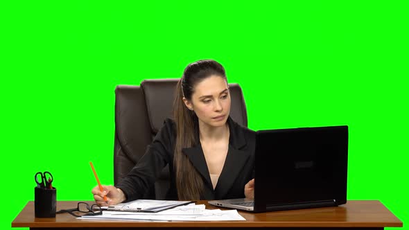 Female Manager Works on a Laptop, Think, Takes Notes Then Smile with Happy. Green Screen Background alt