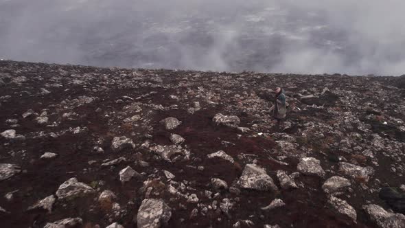 Drone Of Man In Greatcoat Standing Through Misty Landscape alt