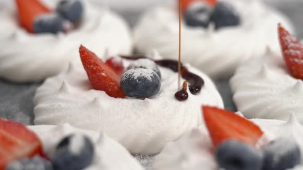 Chocolate is Poured on Meringue with Powdered Sugar Blueberries and Strawberries alt