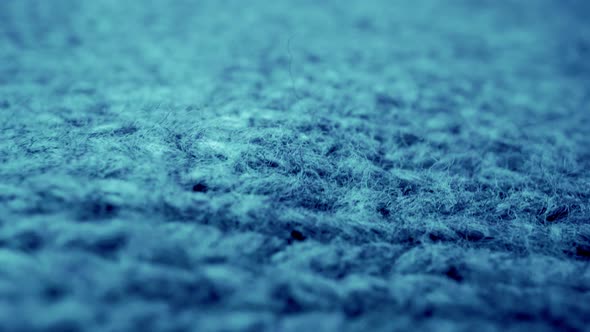 Extreme detail view of sheep wool cloth texture flowing in macro dolly shot. alt