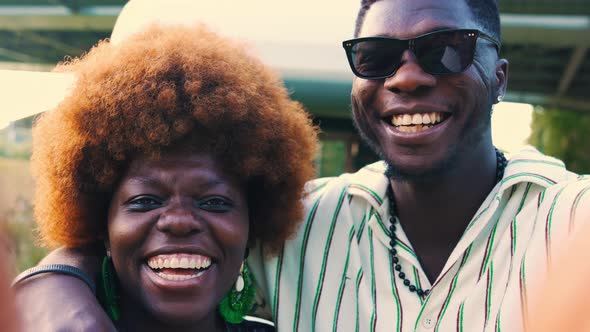 AfroAmerican Woman and Man Smiling and Taking a Selfie Outdoors Medium Closeup alt