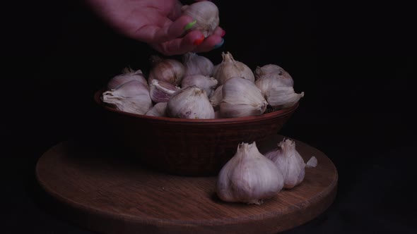 Pile of Whole Bulbs of Garlic in Ceramic Bowl on Table alt