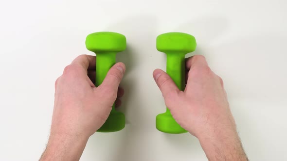 Hand with green Dumbbells on white background. Close up,