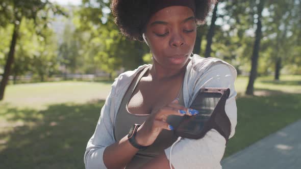 Sportive Woman Using Smartphone in Armband Outdoors alt