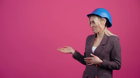 Beautiful Blonde Mature Woman Recommends a Product on the Left Side Wears an Engineer's Helmet on alt