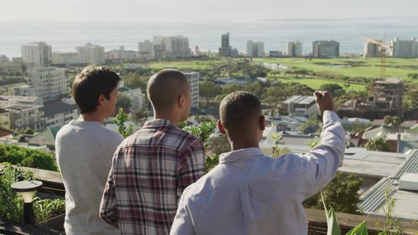 Group of friends looking at the landscape on a rooftop alt