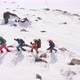 four tourists follow each other through the high snow, helping themselves with ski poles. The last t - VideoHive Item for Sale