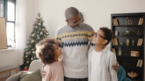 Happy African American Senior Man Embracing His Grandchildren Smiling to Each Other at Home with alt