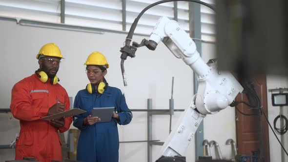 engineer cooperation male and female technician maintenance control relay robot arm alt