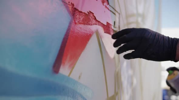 Graffiti artist touching the painted wall 4k alt