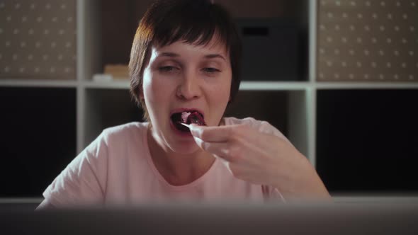 Young woman student watching TV shows or movies on a laptop at home. Homeschooling and study. alt