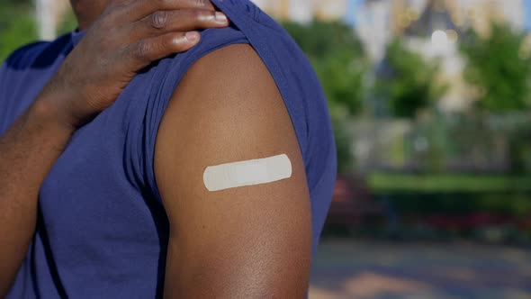 Afroamerican Man Patient Shows Medical Plaster Demonstrates Vaccine Injection