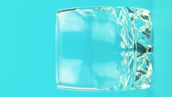 Vertical Video Closeup Shot of Milk Cold Beverage Drink Pooring Into Small Beautiful Glass Blue