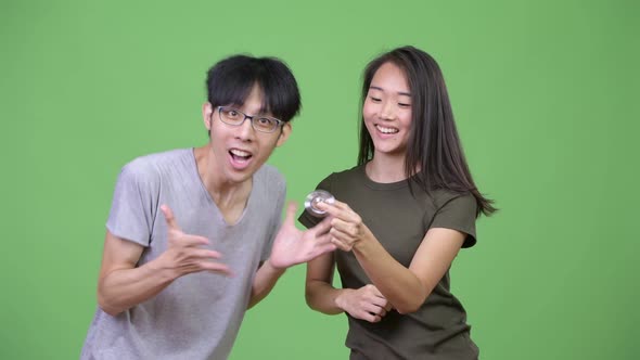 Young Asian Couple Playing with Fidget Spinner Together