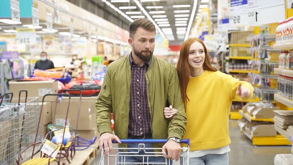 Adorable Redhead Woman Show Something to Husband in Supermarket