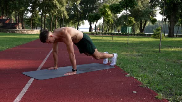 Man Doing Rock Mountain Exercise on Fitness Mat in Park Challenge alt