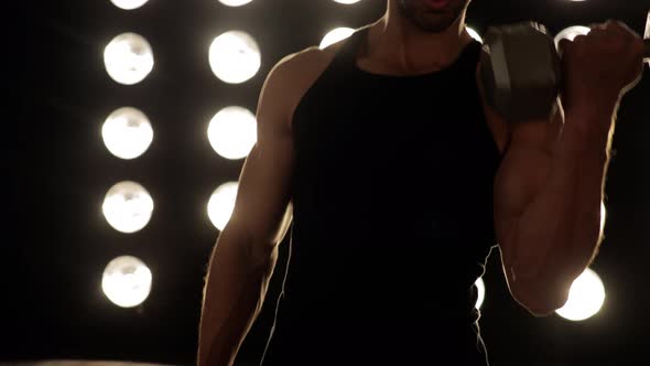 Athletic man workouts out in front of a wall of lights alt