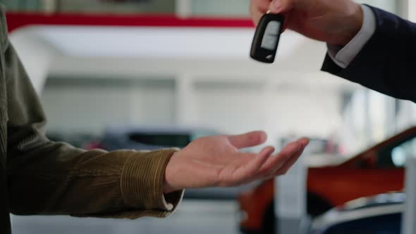 The Hand of the Manager Who Hands the Keys to the Buyer and Shakes His Hand alt