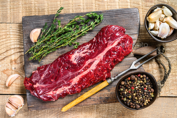 Raw skirt machete beef meat steak on a cutting board with knife. wooden  background. Stock Photo by composter-box