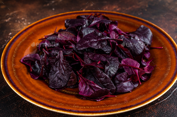 Raw Ruby or red chard salad Leafs on a rustic plate. Dark background. Top view