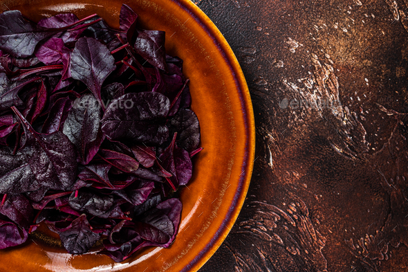 Raw Ruby or red chard salad Leafs on a rustic plate. Dark background. Top view. Copy space