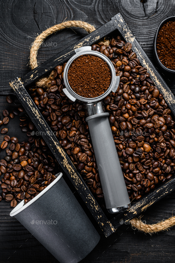 Ground Coffee in Portafilter for Espresso in a wooden tray with coffee