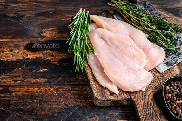 Raw Chicken Cutlets on a Cutting Board: Cutting chicken breasts