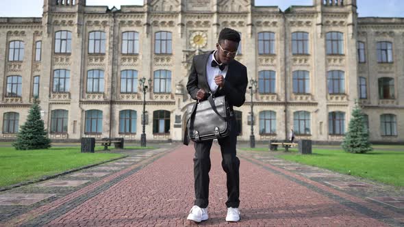 Wide Shot Portrait of Joyful Graduated African American Student in Formal Suit with Attache Bag alt