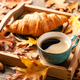 Autumn background with cup of black coffee, croissant and fall oak leaves - PhotoDune Item for Sale