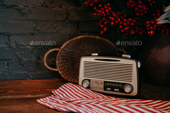 Retro radio on wooden table with wicker basket and floral decor. Vintage style - Stock Photo - Images