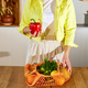 Woman in yellow jacket unpacking shopping mesh eco bag - PhotoDune Item for Sale