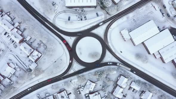 Aerial view of traffic on a roundabout with snow on the side of the road