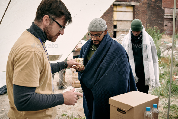 Male volunteer giving humanitarian help to migrants
